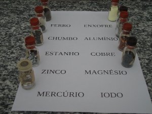 Fotografia de uma relao de elementos qumicos com frascos contendo as substncias simples que os representam.